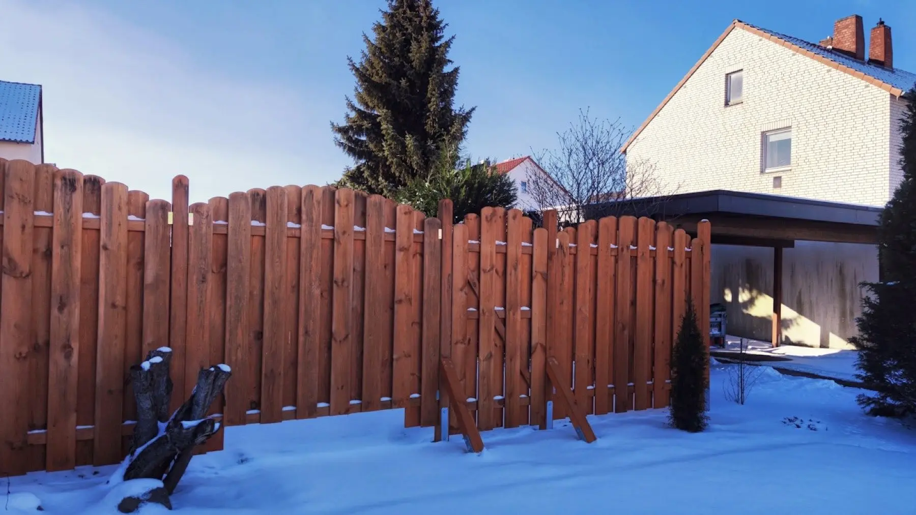 Stained wood fence in a snow-covered yard